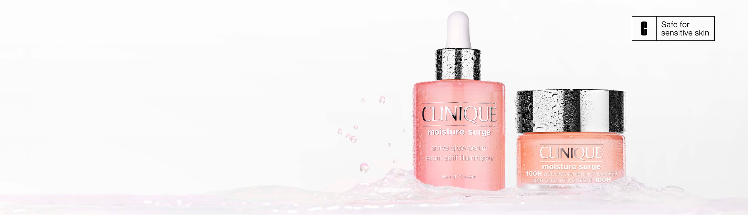 Moisture Surge Serum and 100H Moisturiser stood in a pool of brightly lit, clear water, with hydrating droplets splashing up